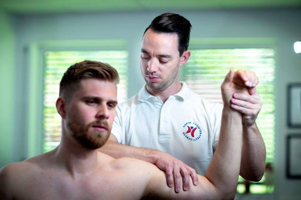 Manuellterapeut behandler en pasient som lider av  overekstremitet i skulderen