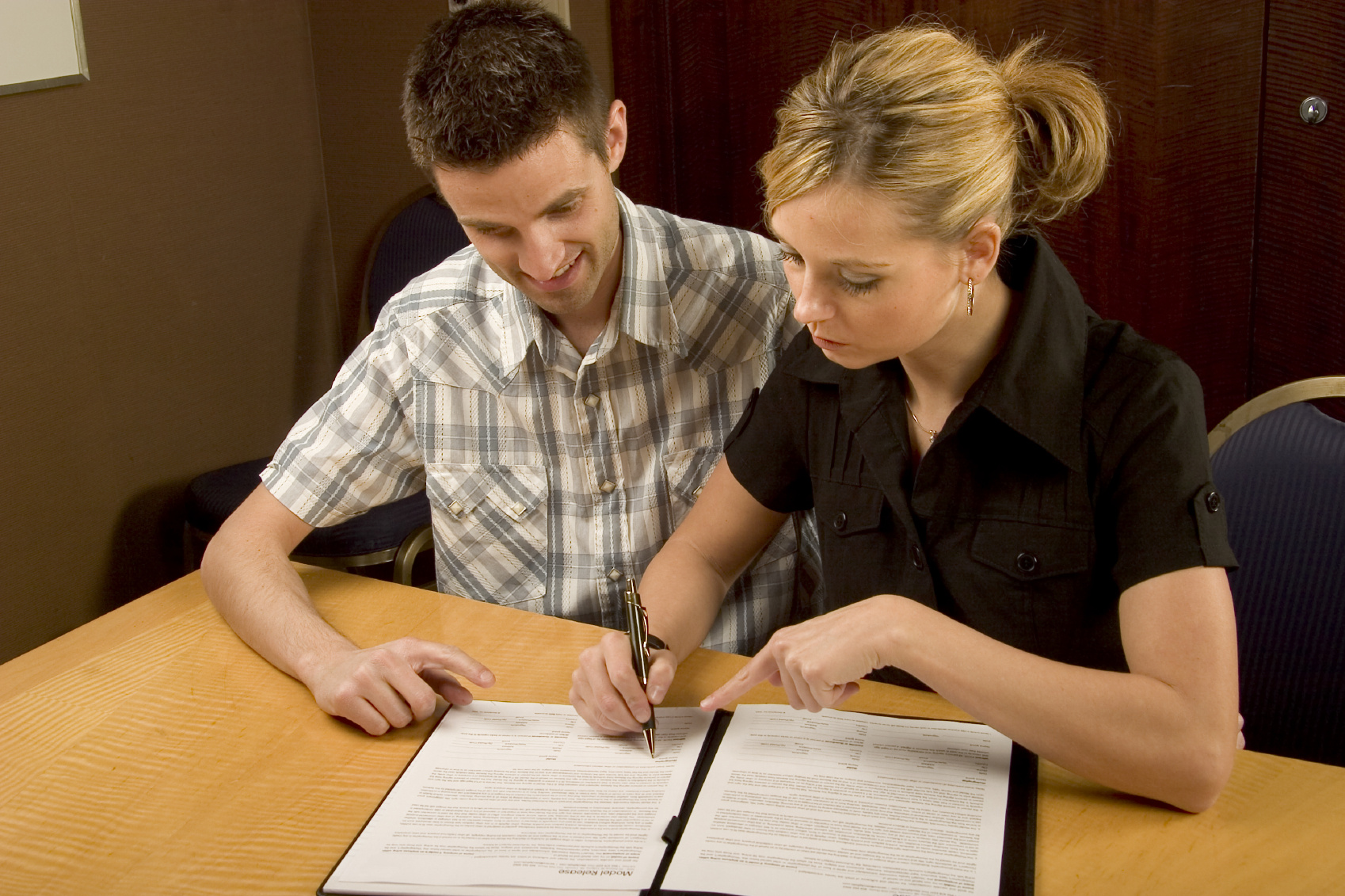 To personer går gjennom og signerer en avtale